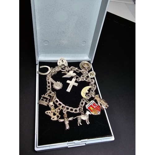 144 - A good 925 silver charm bracelet with 13x different silver charms and 925 silver padlock clasp with ... 