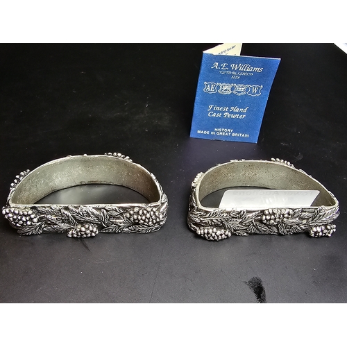 147 - A hallmarked silver napkin ring along with a pair of ornate hand cast pewter napkin rings with a gra... 