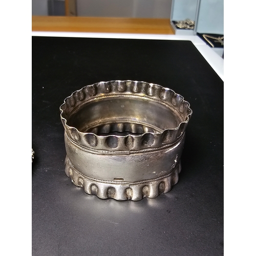 147 - A hallmarked silver napkin ring along with a pair of ornate hand cast pewter napkin rings with a gra... 