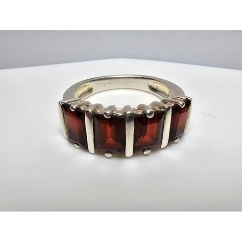 136 - A chunky 925 silver dress ring inset with 4 large faceted garnet stones, in good clean condition and... 