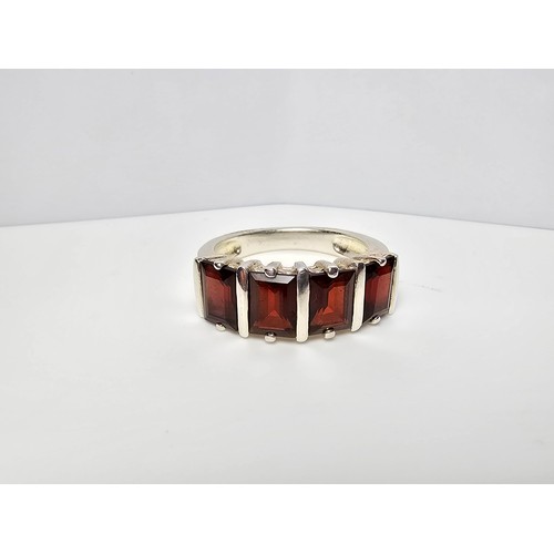 136 - A chunky 925 silver dress ring inset with 4 large faceted garnet stones, in good clean condition and... 