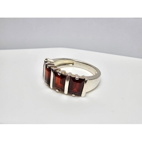 136 - A chunky 925 silver dress ring inset with 4 large faceted garnet stones, in good clean condition and... 