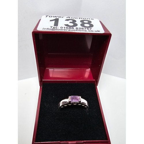 138 - A pretty 925 silver ring inset with a faceted baguette cut amethyst gemstone with a pierced heart de... 