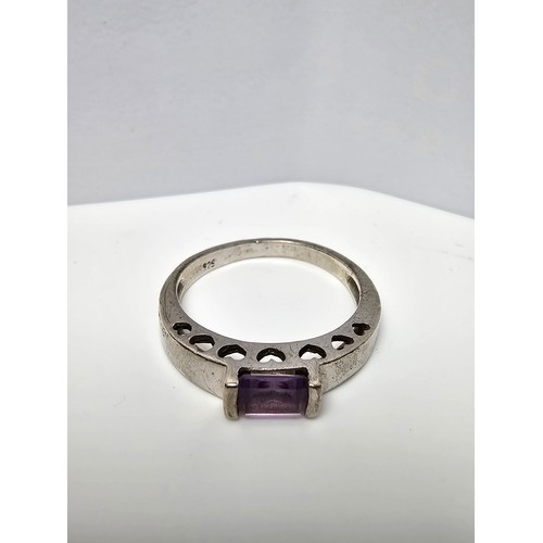 138 - A pretty 925 silver ring inset with a faceted baguette cut amethyst gemstone with a pierced heart de... 