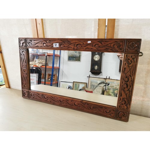 91 - Vintage well carved oak wall mirror in good overall condition. Measures 79cm x 46.5cm.