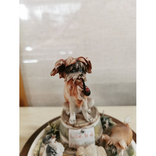 113 - Vintage Capodimonte figure of a dog with a tobacco pipe sitting on a barrel with dogs playing around... 