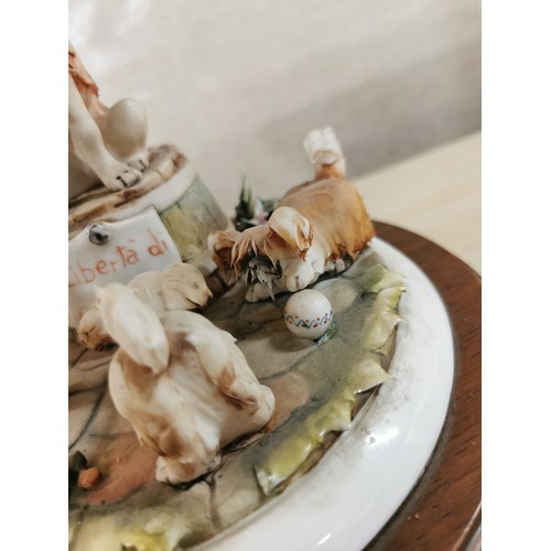 113 - Vintage Capodimonte figure of a dog with a tobacco pipe sitting on a barrel with dogs playing around... 