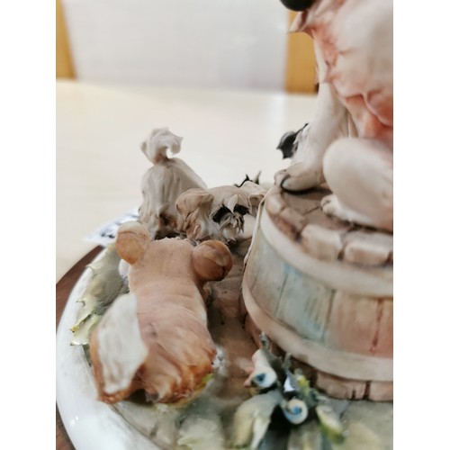 113 - Vintage Capodimonte figure of a dog with a tobacco pipe sitting on a barrel with dogs playing around... 