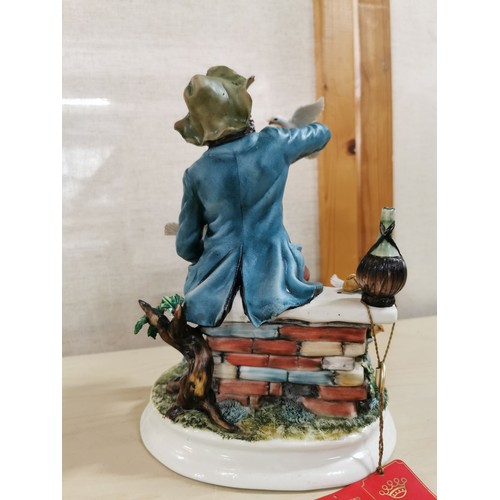 115 - Vintage Capodimonte porcelain figure of a seated man on a wall surrounded by doves. Very small nibbl... 