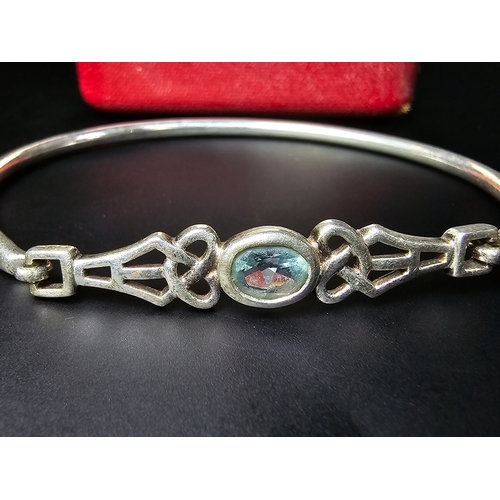 175 - A good 925 silver bangle inset with a faceted blue topaz stone, in the style of Charles Rennie Macki... 