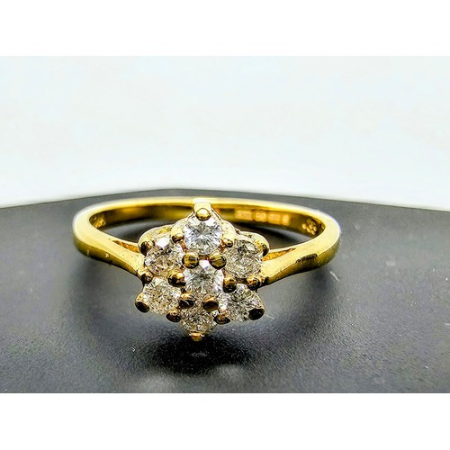 215 - A stunning hallmarked 9ct yellow gold diamond cluster ring inset with 7 round diamond stones which a... 