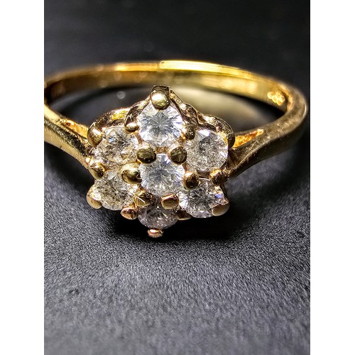 215 - A stunning hallmarked 9ct yellow gold diamond cluster ring inset with 7 round diamond stones which a... 