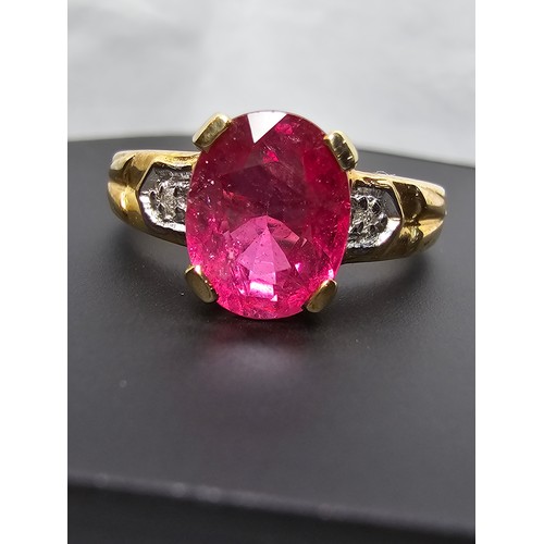 307 - Stunning hallmarked 9ct yellow gold ring inset with a large oval natural ruby faceted gemstone with ... 