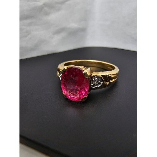 307 - Stunning hallmarked 9ct yellow gold ring inset with a large oval natural ruby faceted gemstone with ... 