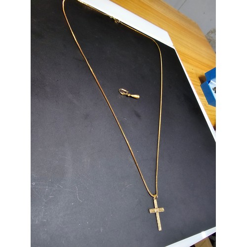 305 - A 9ct yellow gold cross pendant set on a very long gold plated 27