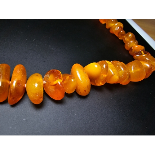 191 - A good quality vintage genuine egg yolk amber beaded necklace featuring polished shaped amber beads ... 