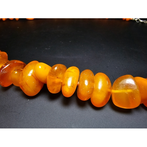 191 - A good quality vintage genuine egg yolk amber beaded necklace featuring polished shaped amber beads ... 