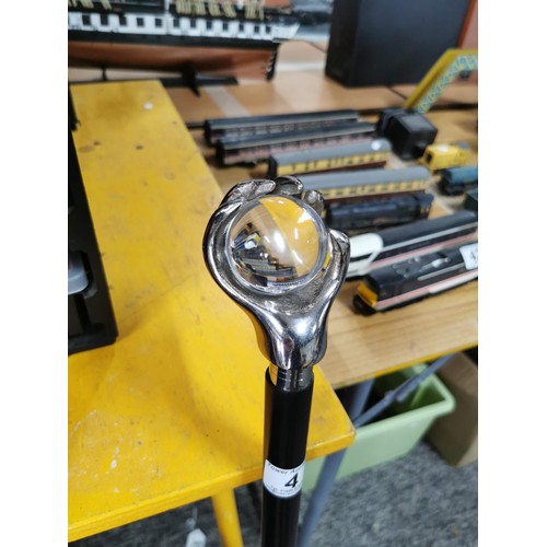 4 - A good quality walking stick in the form of a metal hand holding a glass ball, has a height of 95cm.