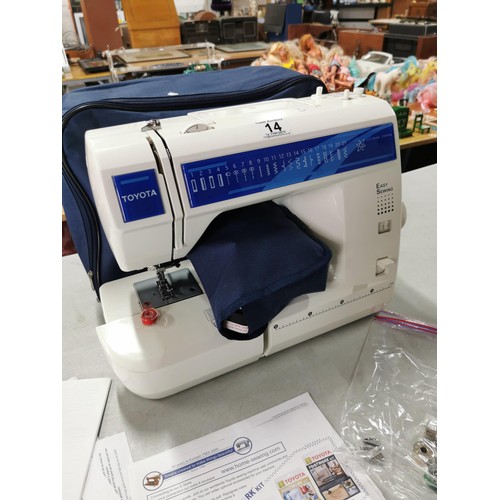 14 - A modern electronic sewing machine by Toyota in very good clean condition. Complete with pedal, orig... 