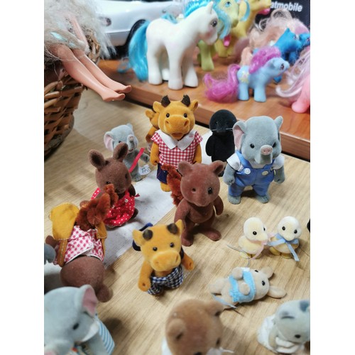 25 - A large collection of various Sylvanian families figures along with many furniture items housed in a... 