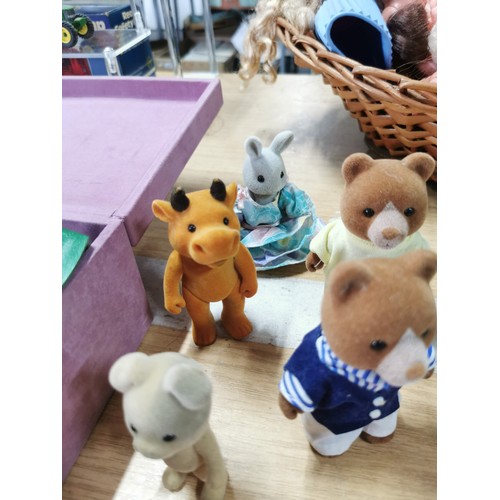 25 - A large collection of various Sylvanian families figures along with many furniture items housed in a... 