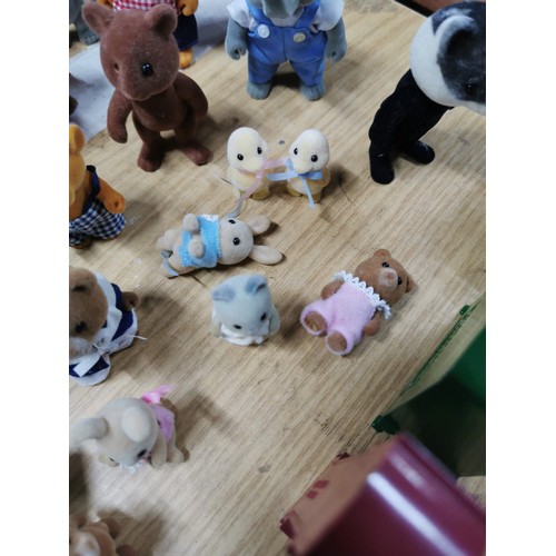 25 - A large collection of various Sylvanian families figures along with many furniture items housed in a... 