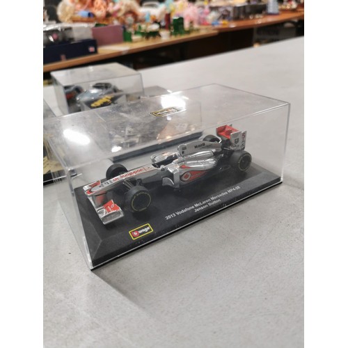 28 - A collection of 8 collectable diecast model cars in their clear presentation boxes to include Burago... 