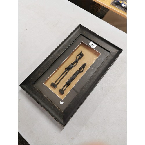 45 - A framed and glazed shadowbox containing African carved tribal art wooden figures. Length of 46cm, w... 