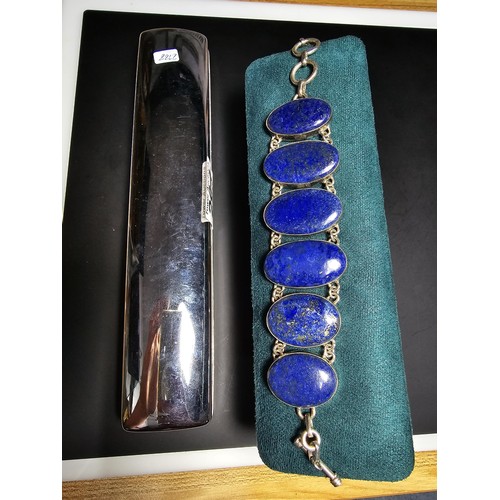 204 - A large 925 silver bracelet inset with 6 large oval lapis lazuli stones presenting vibrant blue natu... 