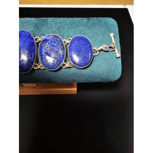 204 - A large 925 silver bracelet inset with 6 large oval lapis lazuli stones presenting vibrant blue natu... 