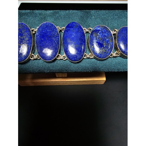 204 - A large 925 silver bracelet inset with 6 large oval lapis lazuli stones presenting vibrant blue natu... 