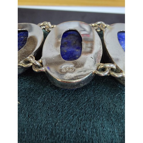 204 - A large 925 silver bracelet inset with 6 large oval lapis lazuli stones presenting vibrant blue natu... 