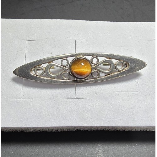 207 - A pretty hallmarked 925 silver brooch with a pierced design inset with a tigers eye cabochon stone, ... 