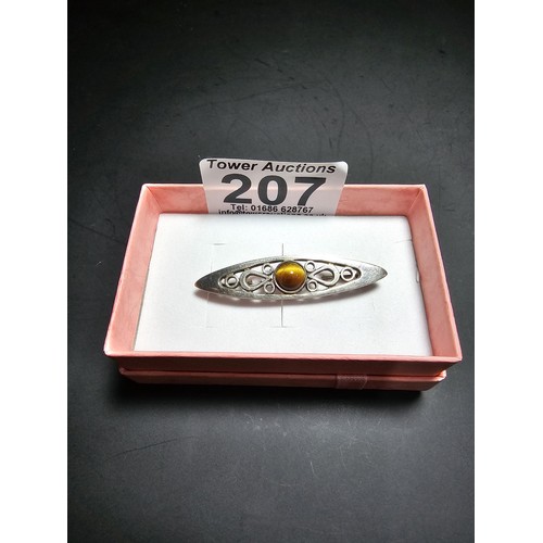 207 - A pretty hallmarked 925 silver brooch with a pierced design inset with a tigers eye cabochon stone, ... 