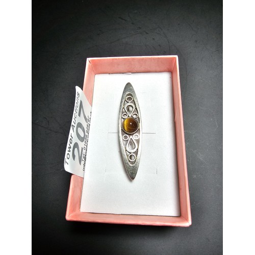 207 - A pretty hallmarked 925 silver brooch with a pierced design inset with a tigers eye cabochon stone, ... 