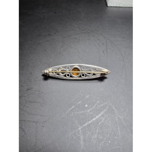 207 - A pretty hallmarked 925 silver brooch with a pierced design inset with a tigers eye cabochon stone, ... 