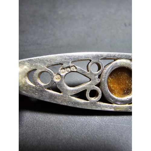 207 - A pretty hallmarked 925 silver brooch with a pierced design inset with a tigers eye cabochon stone, ... 