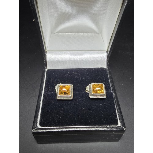 211 - A pair of pretty new and unused 925 silver stud earrings inset with natural Baltic amber, complete w... 