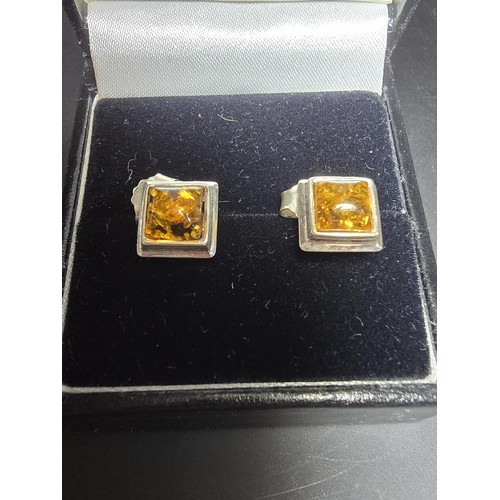 211 - A pair of pretty new and unused 925 silver stud earrings inset with natural Baltic amber, complete w... 