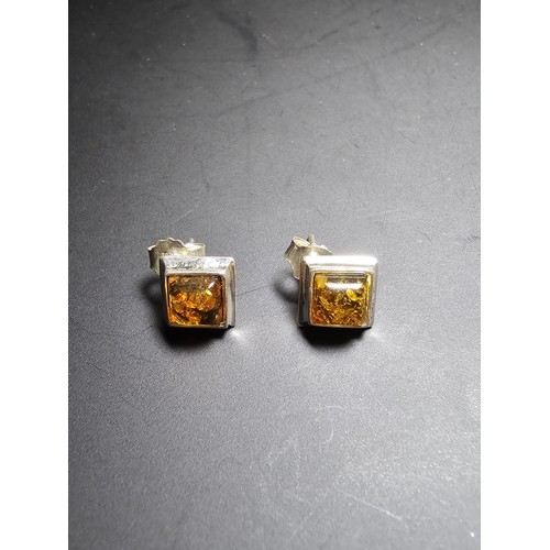 211 - A pair of pretty new and unused 925 silver stud earrings inset with natural Baltic amber, complete w... 