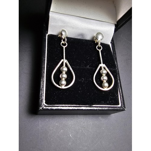 212 - A pair of unused 925 silver stud drop earrings featuring an unusual bead and hoop design, complete w... 