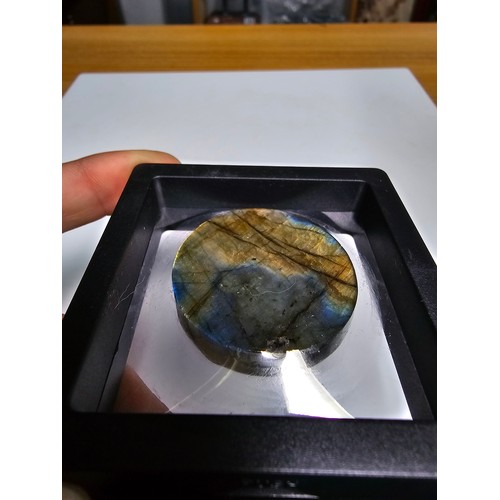 215 - An interesting carved natural labradorite hard stone carved disc with a sun and moon design, present... 