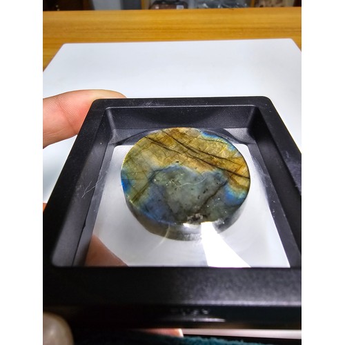 215 - An interesting carved natural labradorite hard stone carved disc with a sun and moon design, present... 