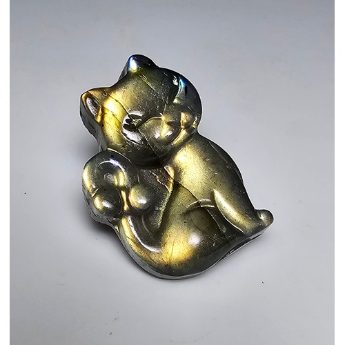 216 - A stunning labradorite carved cat figure presenting very good flashing colours throughout of yellows... 