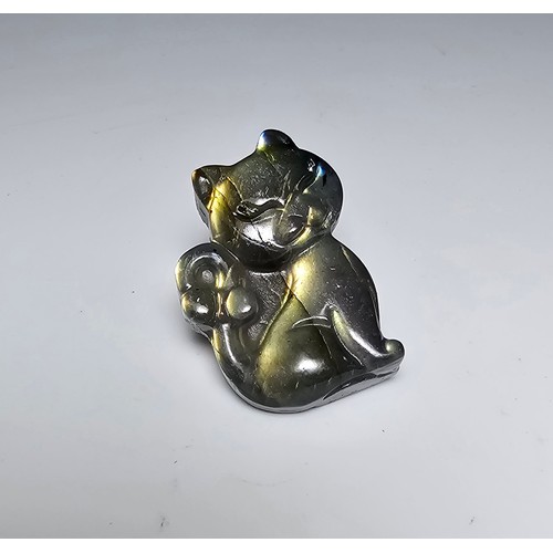 216 - A stunning labradorite carved cat figure presenting very good flashing colours throughout of yellows... 