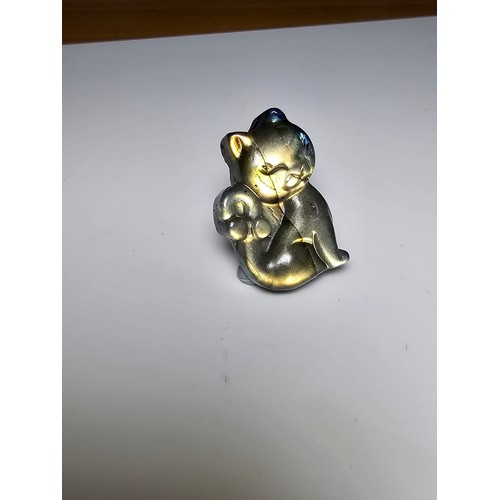 216 - A stunning labradorite carved cat figure presenting very good flashing colours throughout of yellows... 