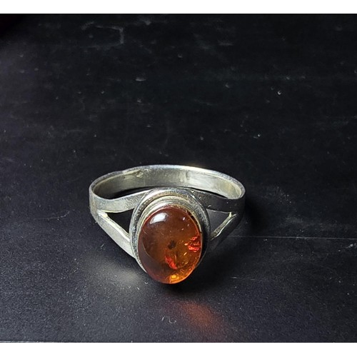 210 - An attractive 925 silver dress ring inset with a large natural Baltic amber cabochon stone. In excel... 