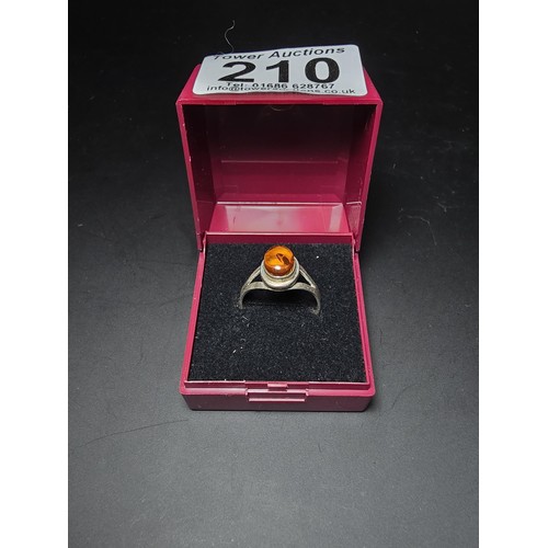 210 - An attractive 925 silver dress ring inset with a large natural Baltic amber cabochon stone. In excel... 