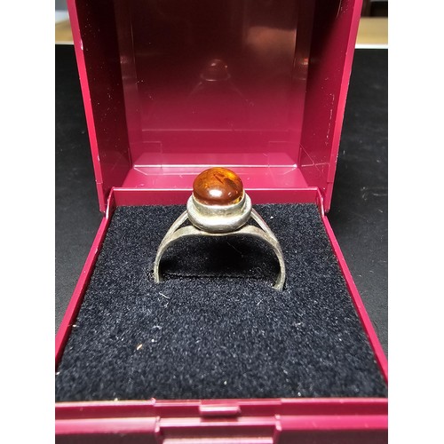 210 - An attractive 925 silver dress ring inset with a large natural Baltic amber cabochon stone. In excel... 