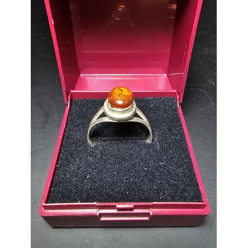 210 - An attractive 925 silver dress ring inset with a large natural Baltic amber cabochon stone. In excel... 